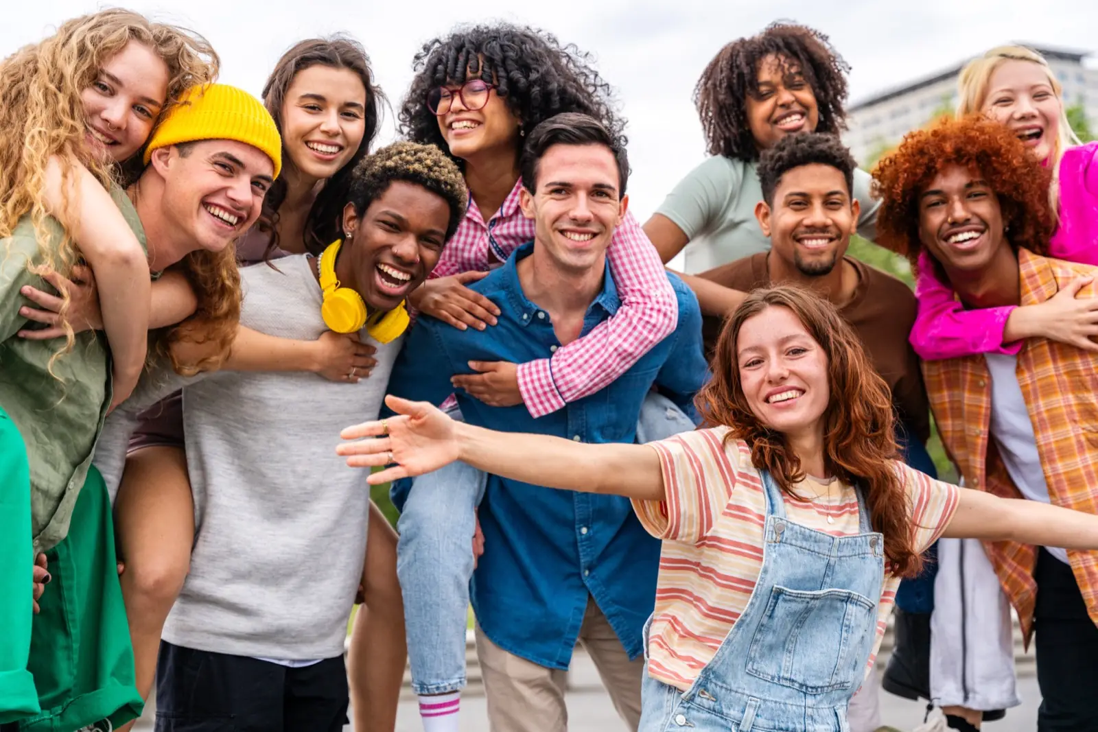 A group of young people hugging and laughing outdoors